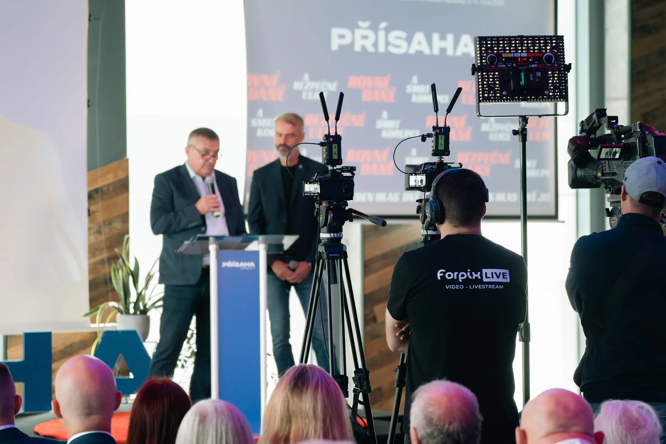 Hovorcovia pri rečníckom pulte a kamera Forpix Live priamo pred nimi