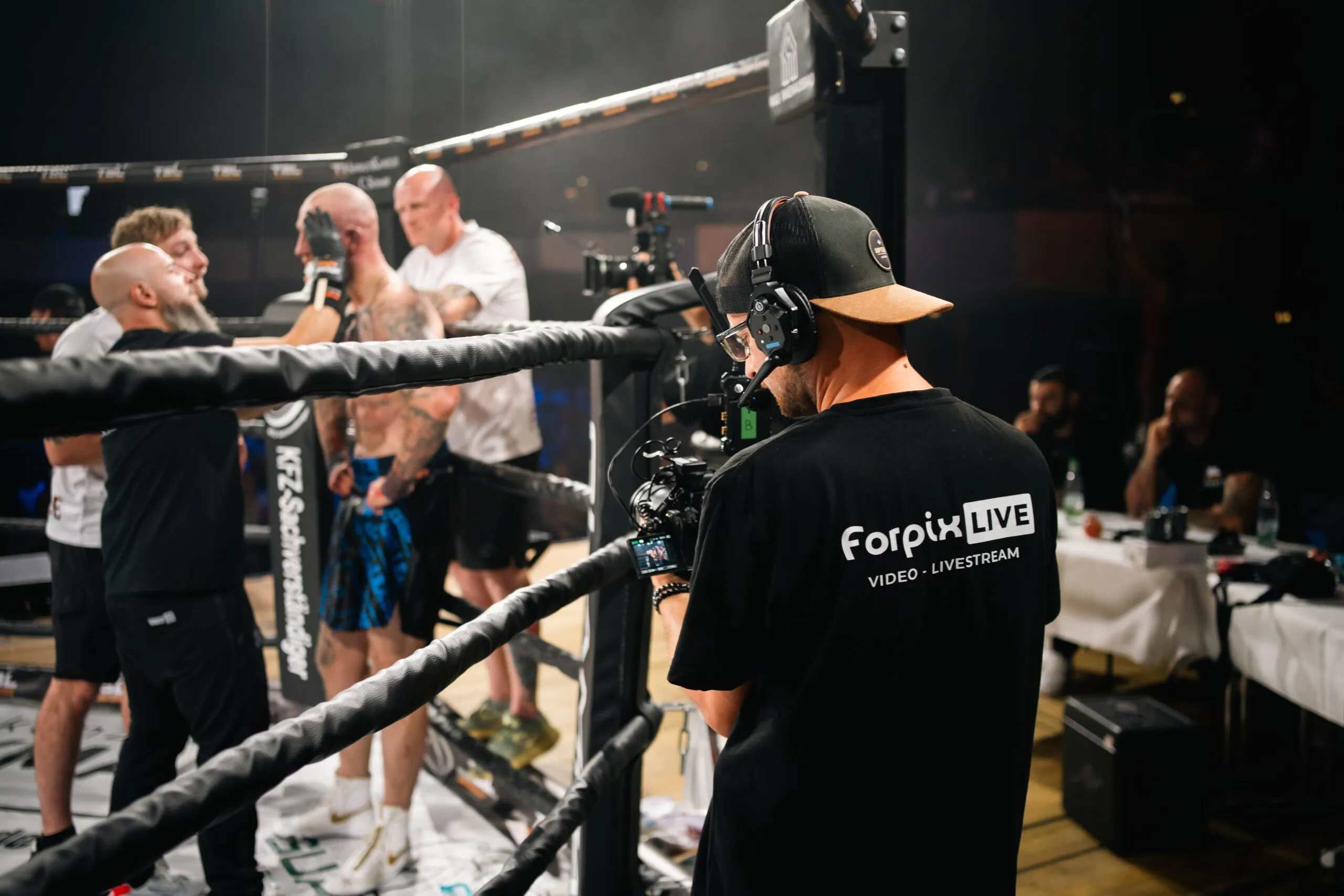 Camera operator filming fighters in the ring at a gala night