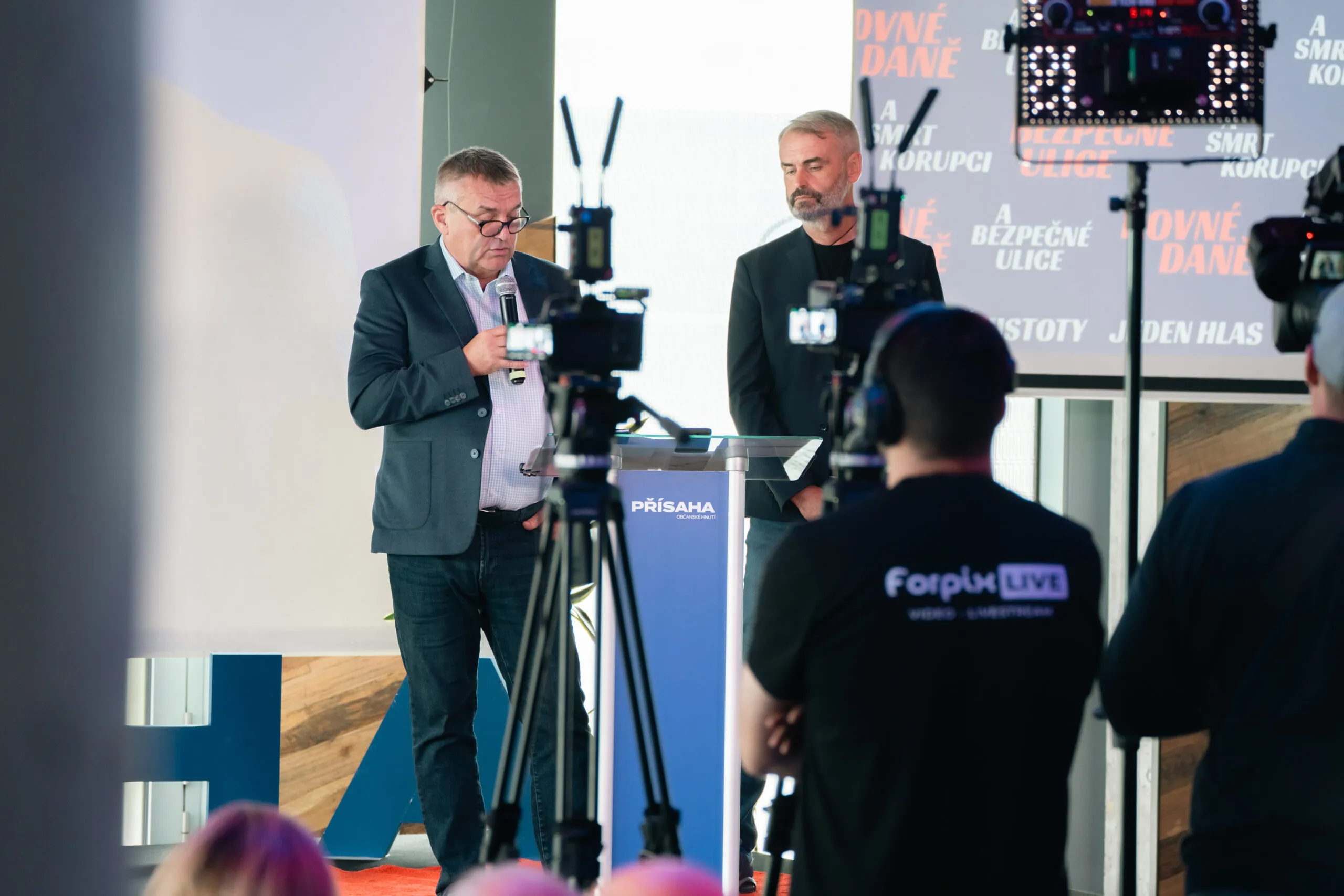 Kameraman Forpix Live sníma dvoch hovorcov na tlačovej konferencii
