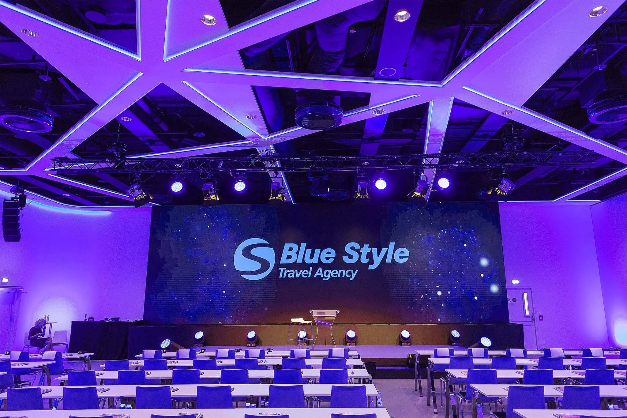 The Cubex hall lit purple, with an LED wall behind the stage and rows of tables